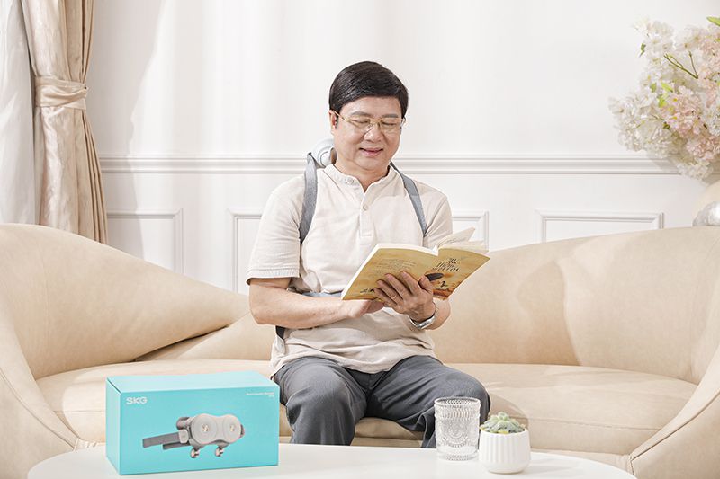 người già sử dụng máy mát xa cổ để giảm đau mỏi cổ vai gáy